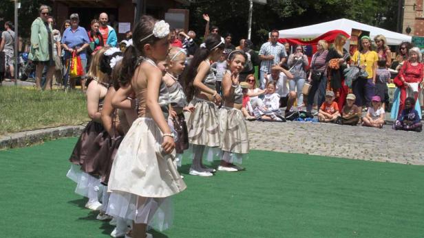 Eine Gruppe junger Mädchen in Kostümen tritt vor einem Publikum auf.