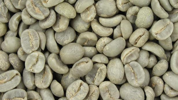 Eine Nahaufnahme von rohen, grünen Kaffeebohnen.
