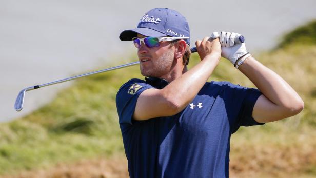 Ein Golfspieler schwingt seinen Schläger auf einem Golfplatz.