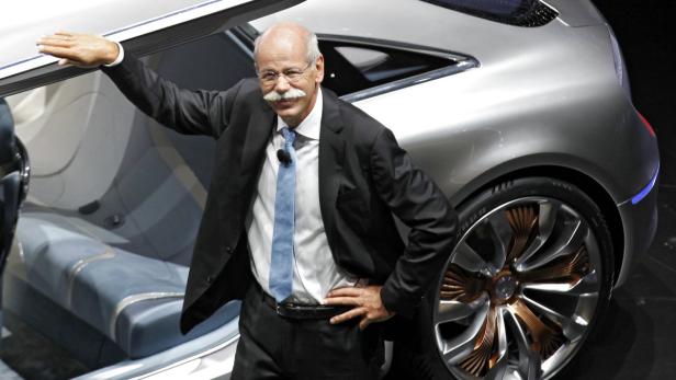 Dieter Zetsche posiert neben einem silbernen Mercedes-Benz-Konzeptfahrzeug.