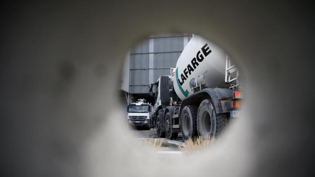 Blick durch ein Betonrohr auf zwei Lafarge-Betonmischer.
