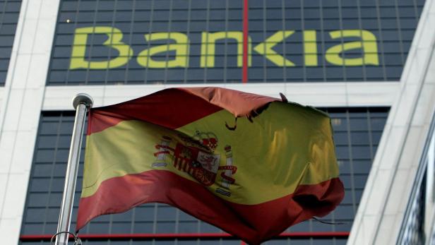 Eine beschädigte spanische Flagge weht vor einem Bankia-Gebäude.