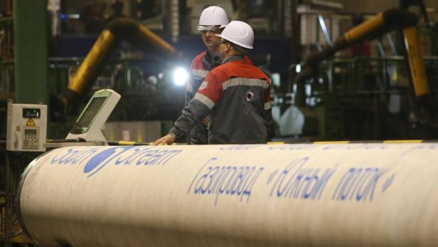 Employees stand near a pipe made for the South Str South Stream: OMV-Chef und EU-Kommission auf Kollisionskurs