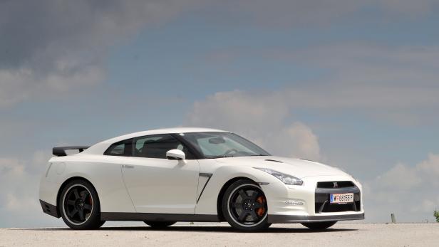 Ein weißer Nissan GT-R vor einem bewölkten Himmel.