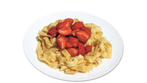 Ein Teller mit Schupfnudeln und frischen Erdbeeren.