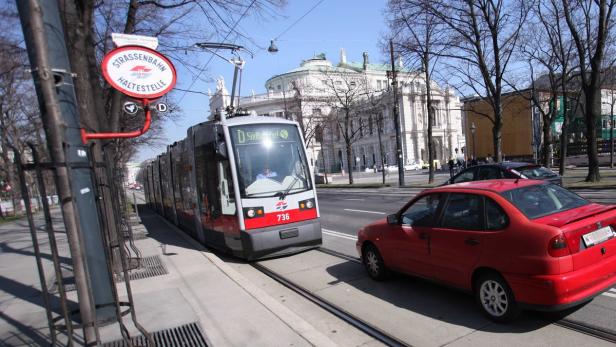 Eine Straßenbahn der Linie D fährt durch Wien, im Hintergrund die Hofburg.