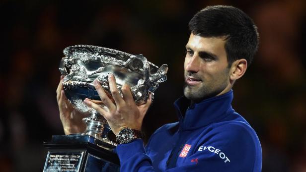 Novak Djokovic hält eine silberne Trophäe in seinen Händen.