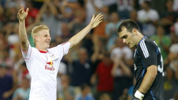 Ein jubelnder Fußballspieler im Trikot von Red Bull Salzburg mit erhobenen Armen.