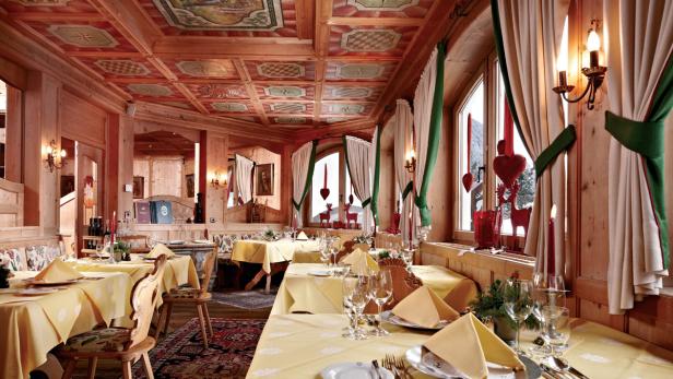 Ein traditionell eingerichtetes Restaurant mit Holztäfelung und gelben Tischdecken.