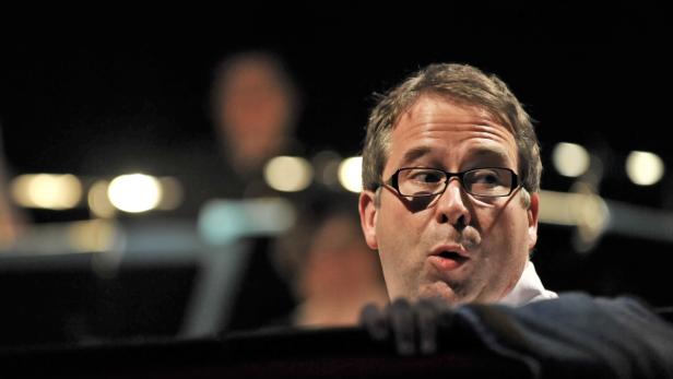 Ein Mann mit Brille schaut aufmerksam zur Seite.