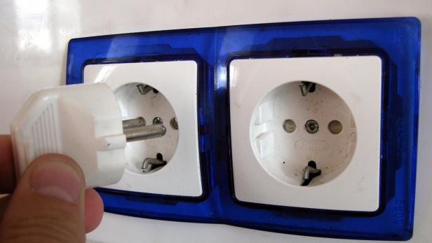 Ein Stecker wird in eine Steckdose gesteckt.