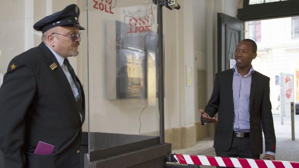 Ein Zollbeamter kontrolliert einen Mann an einem Grenzübergang.