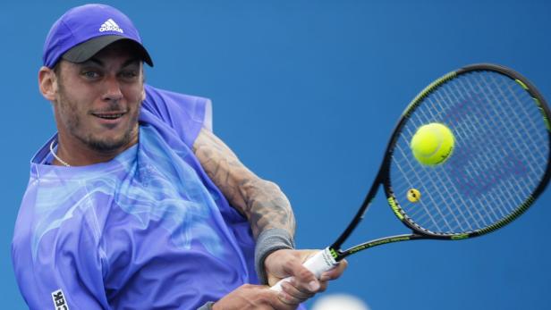 Ein Tennisspieler schlägt einen gelben Tennisball mit seinem Schläger.