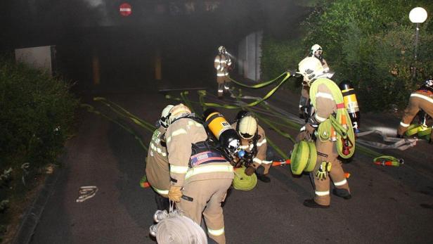 Einsatzkräfte der Feuerwehr vor der Tiefgarageneinfahrt.