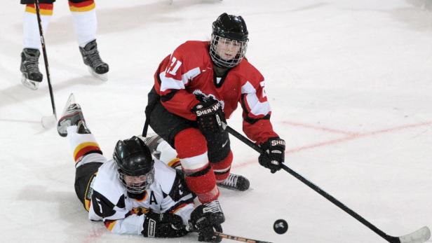 Zwei Eishockeyspieler kämpfen um den Puck auf dem Eis.