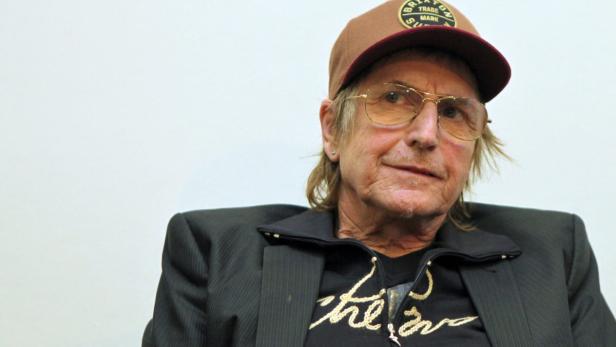 Ein Mann mit Brille und Kappe blickt in die Ferne.