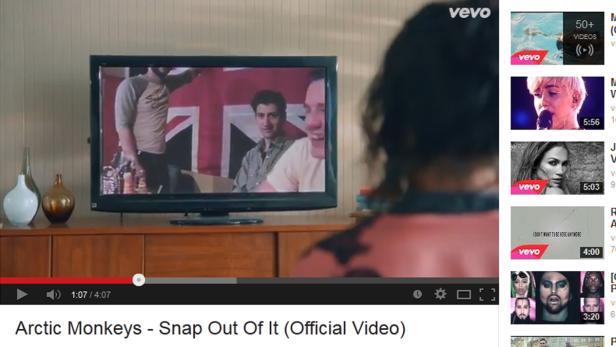 Auf einem Fernseher läuft das Musikvideo „Snap Out Of It“ von den Arctic Monkeys.