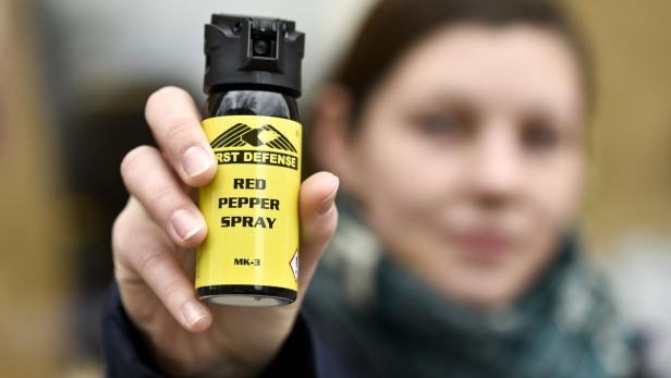 Eine Frau hält eine Dose Pfefferspray der Marke „First Defense“ in die Kamera.