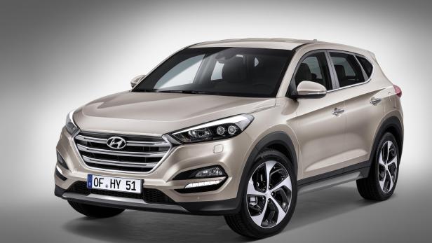 Ein goldfarbener Hyundai Tucson steht vor einem neutralen Hintergrund.