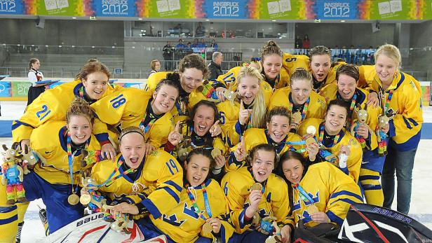 Das schwedische Fraueneishockeyteam feiert mit Goldmedaillen bei den Olympischen Jugendspielen 2012 in Innsbruck.