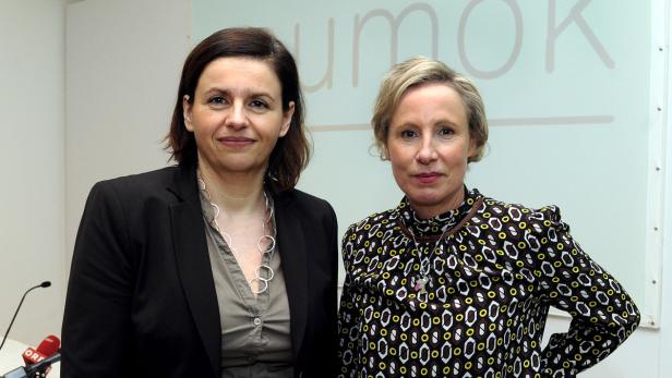 Zwei Frauen stehen vor einer Wand mit der Aufschrift „UMOK“.