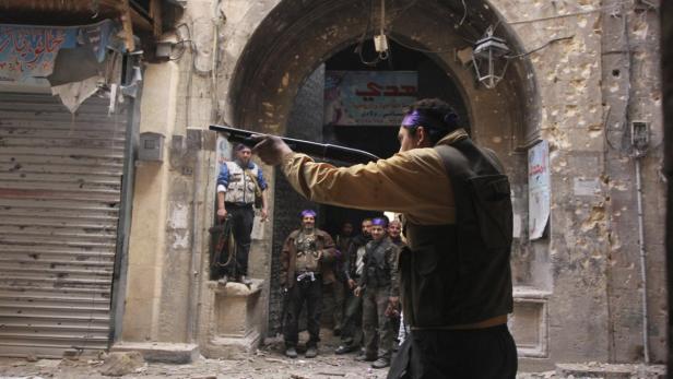 A member of the Free Syrian Army aims his weapon during what they say are clashes against forces loyal to President Bashar al-Assad in a street in Aleppo February 26, 2013. REUTERS/Giath Taha (SYRIA - Tags: CONFLICT POLITICS)