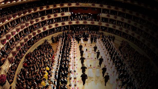 Blick von oben auf einen Ballsaal mit vielen Paaren in Abendgarderobe.