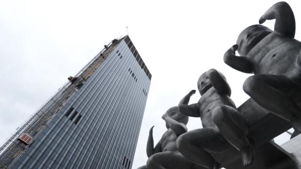 Eine Skulptur von drei Kindern vor einem modernen Hochhaus.