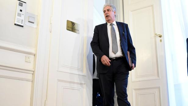 Ein Mann im Anzug verlässt ein Büro mit der Aufschrift „Bundeskanzler“.