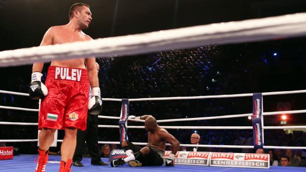 Der Boxer Kubrat Pulev steht im Ring, während sein Gegner am Boden sitzt.