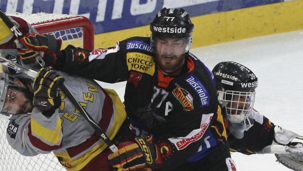 Zwei Eishockeyspieler kämpfen vor dem Tor um den Puck.