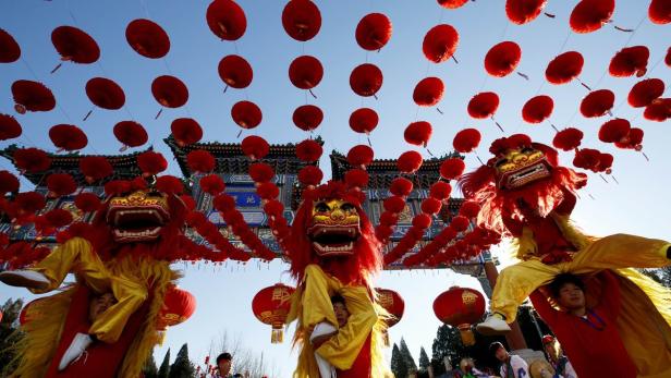 Menschen feiern mit Löwentänzen und roten Laternen das chinesische Neujahrsfest.