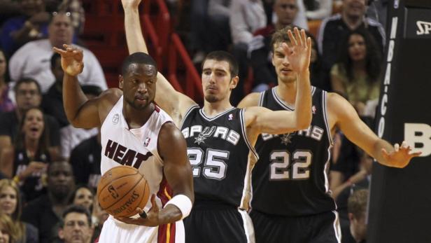 Dwyane Wade von den Miami Heat mit dem Ball, flankiert von zwei Spielern der San Antonio Spurs.