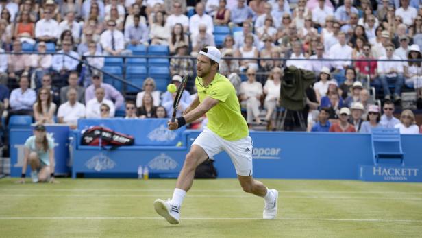 Ein Tennisspieler schlägt den Ball während eines Matches vor Publikum.