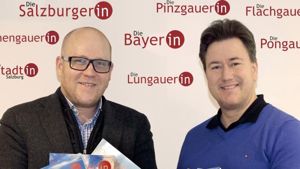 Zwei Männer stehen vor einer Wand mit Logos verschiedener österreichischer Regionen.