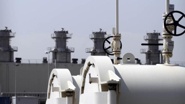 Industrieanlage mit weißen Rohren und Ventilen im Vordergrund.
