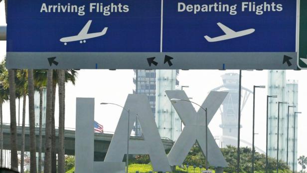 Schilder für ankommende und abfliegende Flüge am Los Angeles International Airport (LAX).