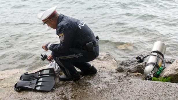 Ein Polizist begutachtet die Tauchausrüstung des verletzten Tauchers.