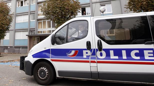 Ein Polizeiwagen steht vor einem Wohnhaus.