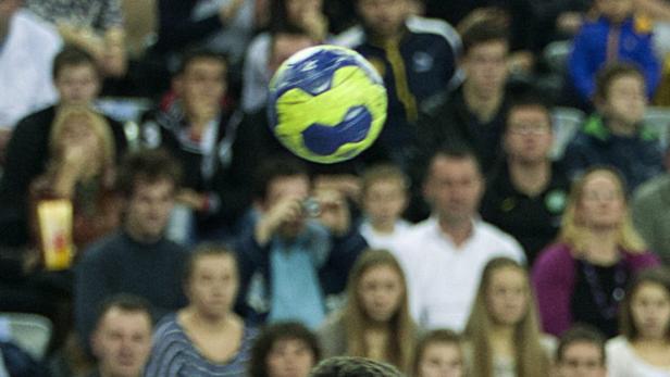 Ein gelb-blauer Ball schwebt vor einer Zuschauermenge.