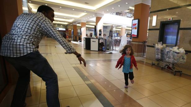 A child runs to safety as armed police hunt gunmen