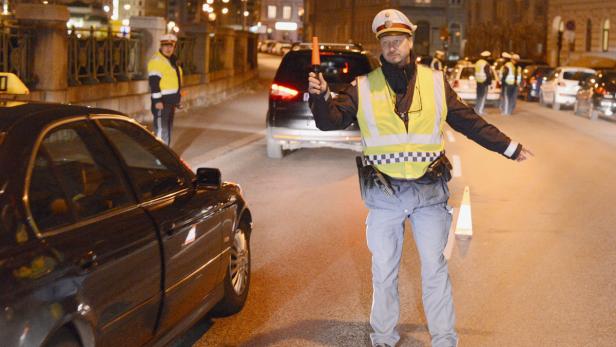Ein Polizist regelt den Verkehr auf einer nächtlichen Straße.