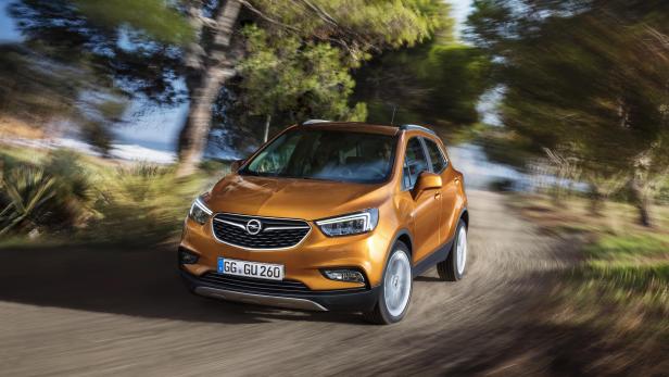 Ein goldfarbener Opel Mokka fährt auf einer Landstraße.