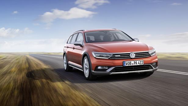 Ein orangefarbener VW Passat Alltrack fährt auf einer Landstraße.