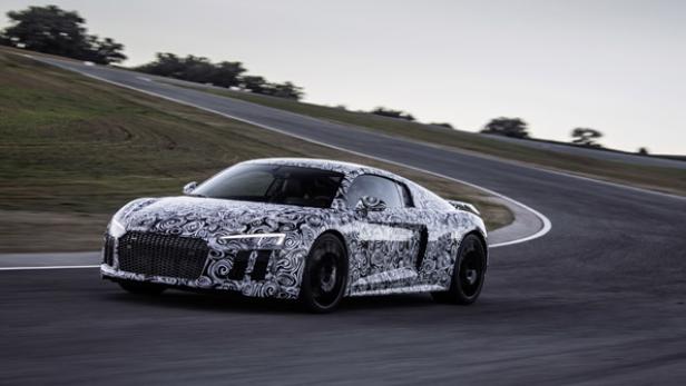 Ein mit einem Muster beklebter Audi R8 fährt auf einer Rennstrecke.