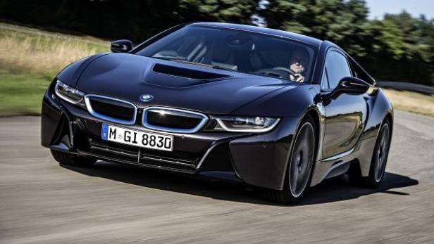 Ein schwarzer BMW i8 fährt auf einer asphaltierten Straße.