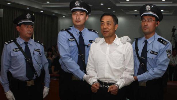 Der frühere chinesische Handelsminister Bo Xilai wird in Handschellen abgeführt.