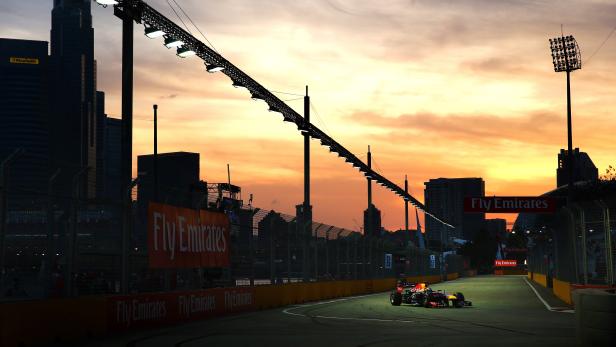 Ein Formel-1-Rennwagen auf einer Strecke in Singapur bei Sonnenuntergang.