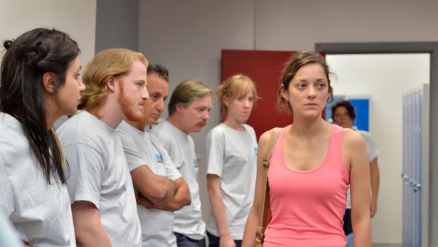 Marion Cotillard und weitere Personen in einem Raum.