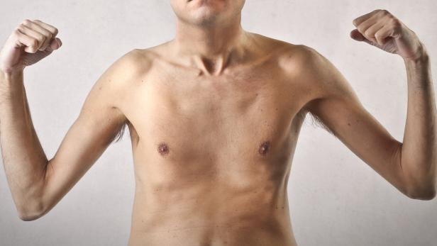 Ein Mann ohne Hemd spannt seine Armmuskeln an.